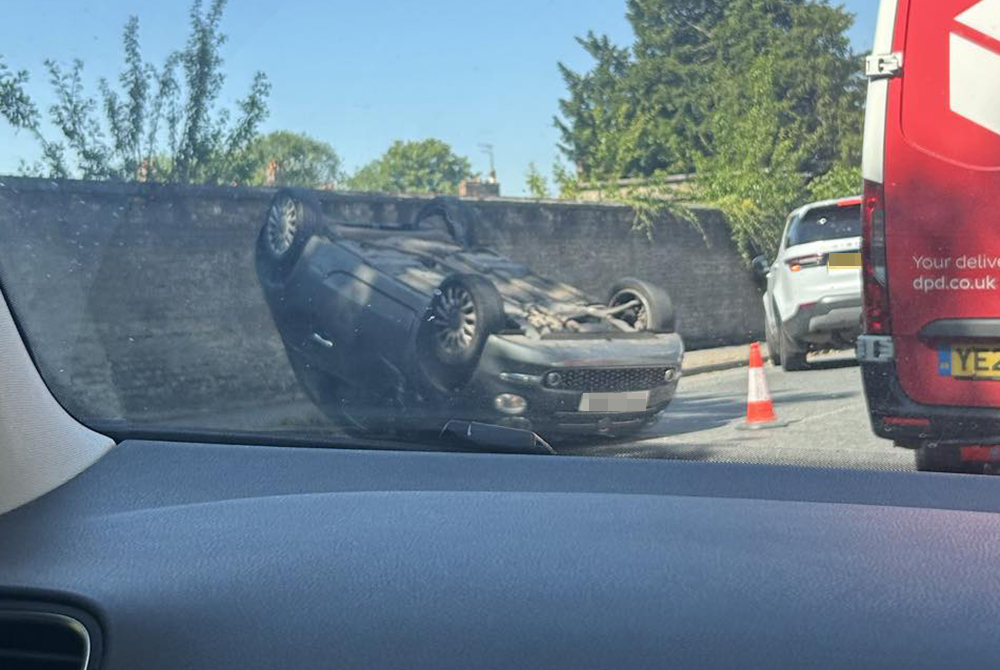 Car crashes and overturns on road near Wiltshire shopping village